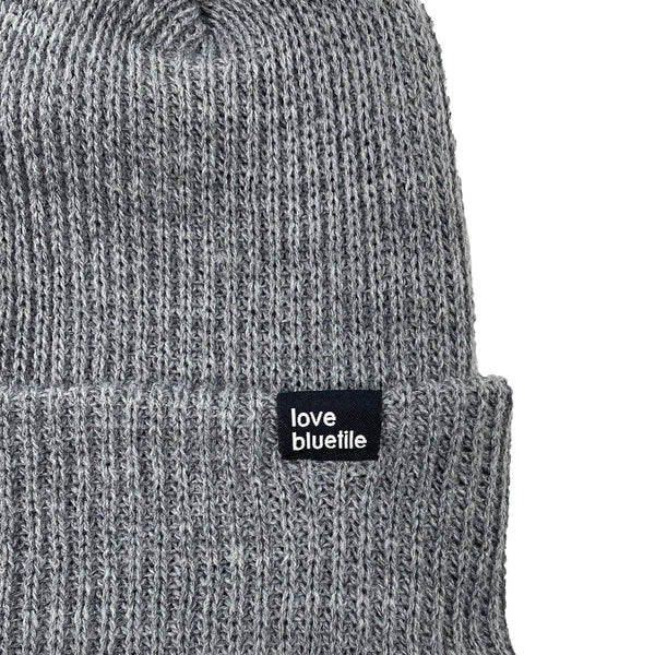 A Bluetile Skateboards knit beanie with a black label on it.