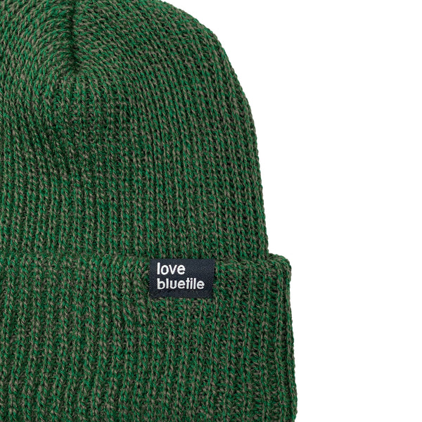 A BLUETILE LOVE ALWAYS KNIT BEANIE FOREST/OLIVE MARBLE with a tag on it.