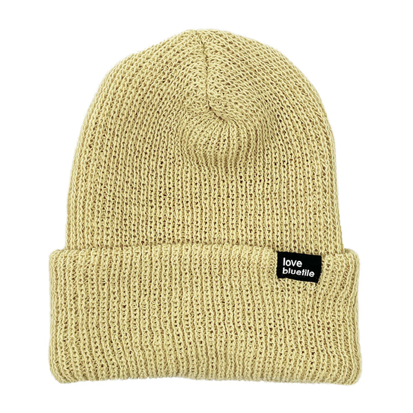 A Vegas Gold BLUETILE LOVE ALWAYS KNIT BEANIE with a black label on it.