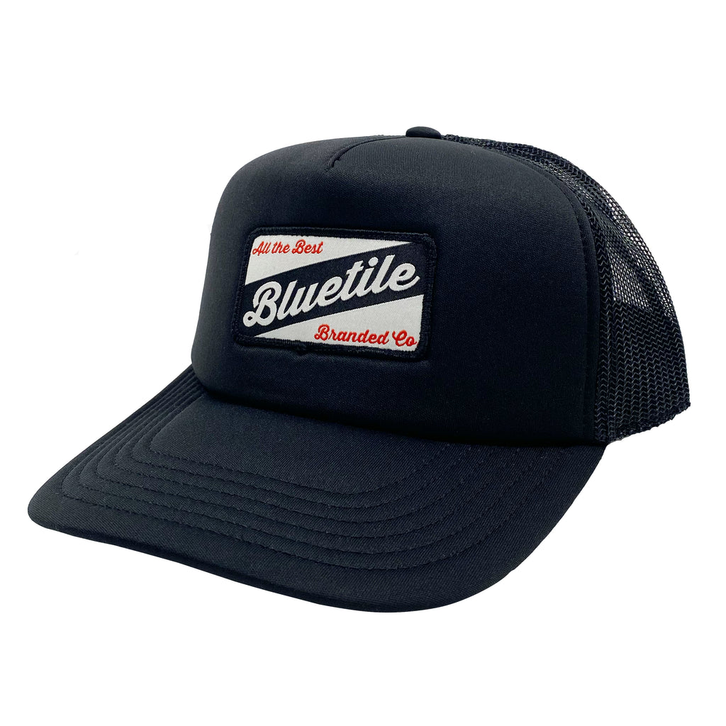 A black trucker hat with the word bluelee on it, featuring a custom Bluetile Skateboards Patch.
