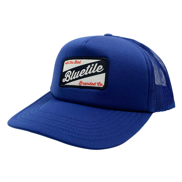 A blue BLUETILE CRAFT PATCH TRUCKER COBALT hat with a blue Bluetile Skateboards logo on it.