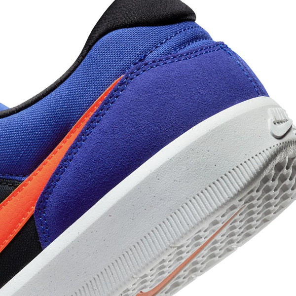 Close-up of the NIKE SB Force 58 Concord/Team Orange-Black-Concord heel and outsole, with a blue and black upper, orange Swoosh, and white sole—available at Bluetile Skateboards in Columbia, SC.