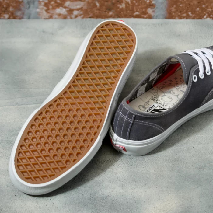 An authentic pair of grey VANS SKATE AUTHENTIC DANIEL JOHNSTON RAVEN sneakers on a concrete floor.