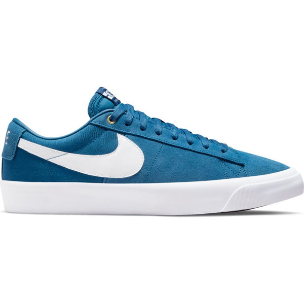 A NIKE SB BLAZER LOW PRO GT COURT BLUE / WHITE sneaker with white accents, including the iconic swoosh logo. The shoe features a low-top design with blue laces and a white rubber sole, perfect for skateboards.