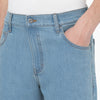 A close up of a person wearing a pair of DICKIES WINGVILLE LOOSE DENIM PANT LIGHT DENIM jeans.