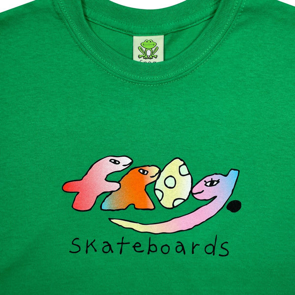 The "FROG DINO TEE KELLY GREEN" by FROG is a green tee featuring colorful, stylized text "Frog," with a frog logo tag at the neckline and the word "Skateboards" printed below.