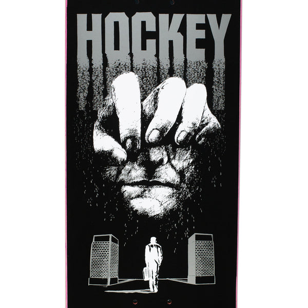 A close up of a Black skateboard deck with a face and a hand.