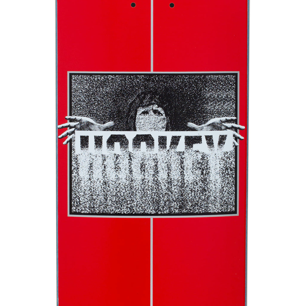 A close up of A red skateboard with a blurry person and the blurry word HOCKEY.