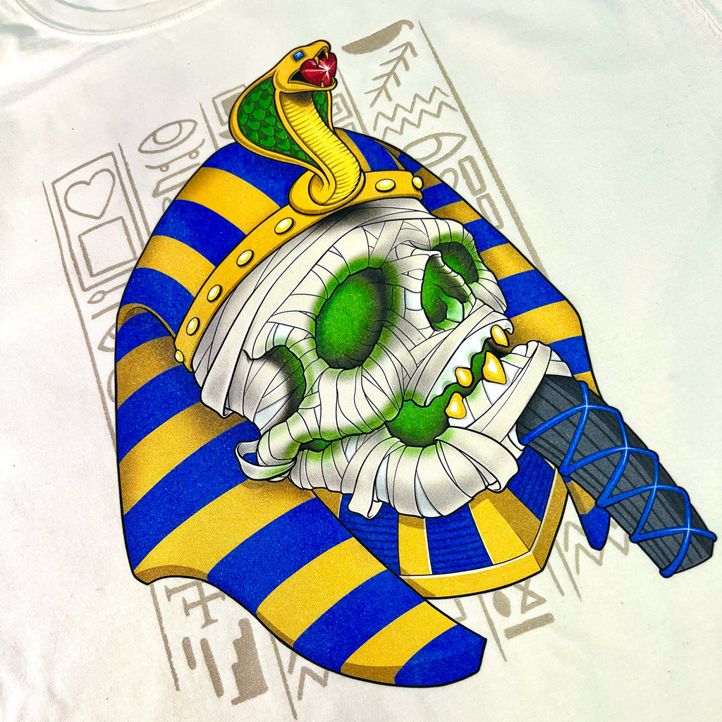 A BLUETILE PHARAOH MUMMY DESERT SAND t-shirt with an Egyptian skull on it, inspired by the pharaohs of ancient Egypt, made by Bluetile Skateboards.