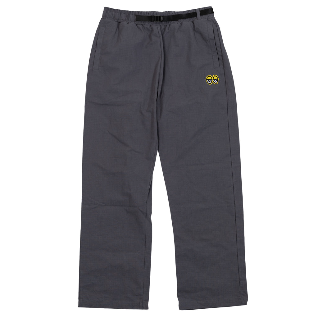 A Deluxe KROOKED EYES PANTS CHARCOAL / YELLOW with a yellow and black logo on the side.