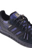 A black and dark blue ADIDAS Handball Top x Mike Arnold sneaker with black laces.