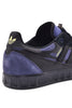 An ADIDAS sneaker in black and dark blue with a yellow stripe.