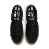 A pair of Nike SB Blazer Low Pro GT Black/White/Gum shoes on a white background.