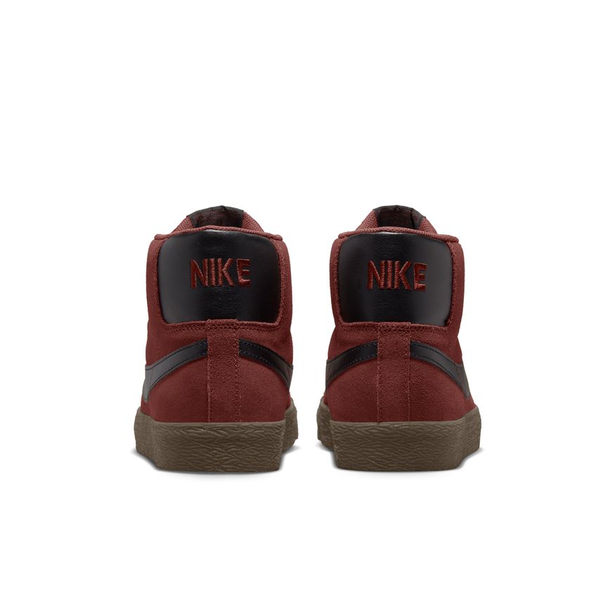 A pair of red Nike sneakers with oxen brown and black accents.