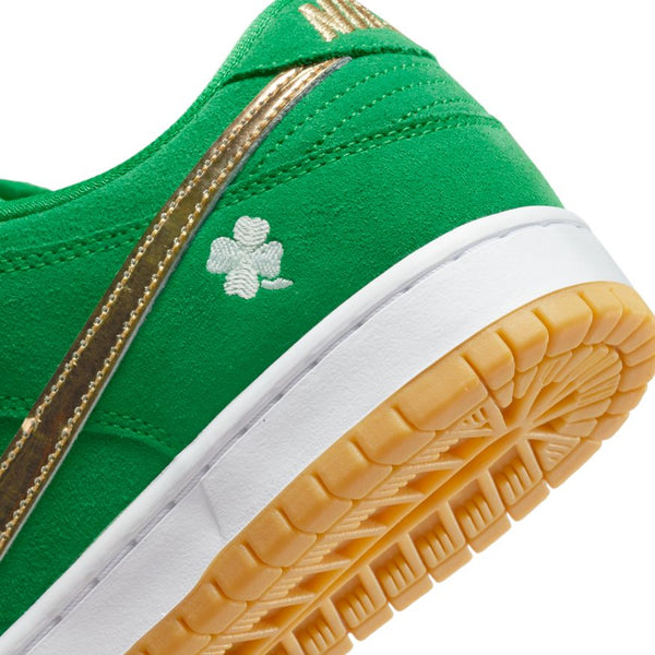 Close-up of the NIKE SB DUNK LOW PRO LUCKY GREEN / METALLIC GOLD by Nike, featuring a gold stripe, white clover emblem, white midsole, and yellow rubber outsole. Available at Bluetile Skateboards.