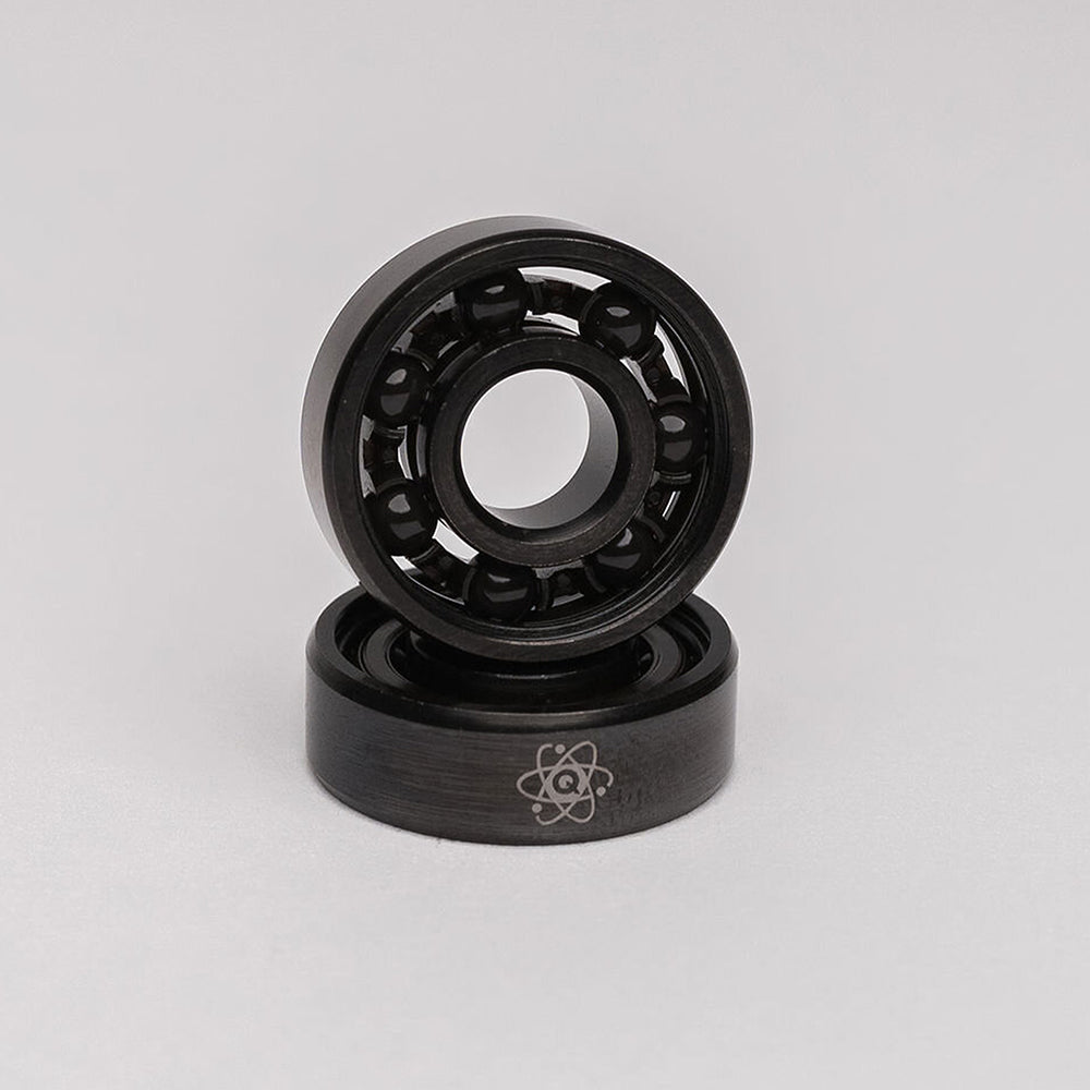 A pair of QUANTUM ATOM CERAMIC HYBRID BEARINGS on a white background, by Quantum Bearings.