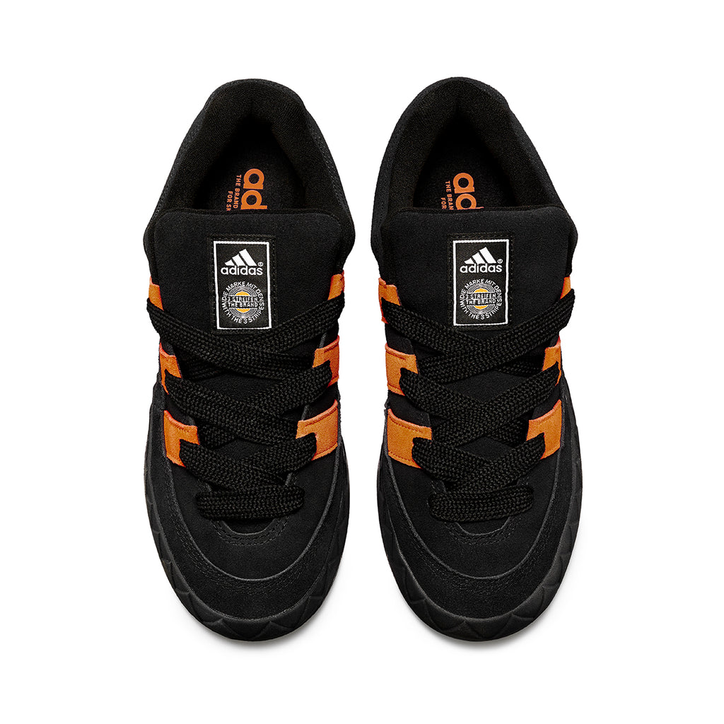 A pair of ADIDAS JAMAL SMITH ADIMATIC BLACK / ORANGE RUSH sneakers by ADIDAS on a white background.