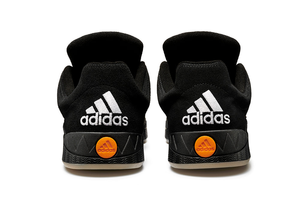 A pair of black and orange ADIDAS JAMAL SMITH ADIMATIC basketball shoes designed by Jamal Smith.
