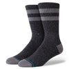 A large pair of black crew Stance socks with striped patterns and blue accents on the toes and heels.