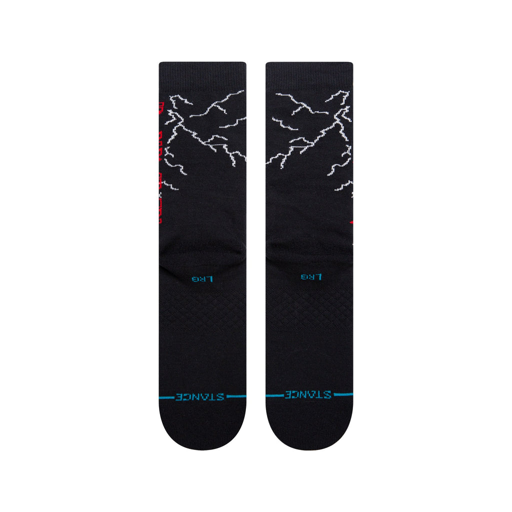 A pair of STANCE SOCKS NIGHT CITY BLACK LARGE with white lightning bolt patterns and blue text on the footbed, inspired by the vibrant energy of a night city.