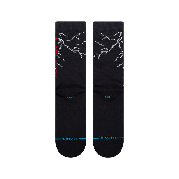A pair of STANCE SOCKS NIGHT CITY BLACK LARGE with white lightning bolt patterns and blue text on the footbed, inspired by the vibrant energy of a night city.