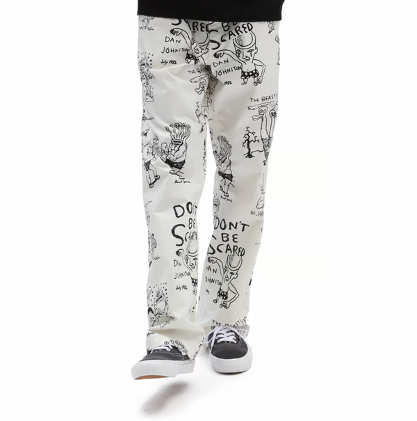A boy wearing VANS X DANIEL JOHNSTON AUTHENTIC CHINO LOOSE FIT pants with cartoons on them.