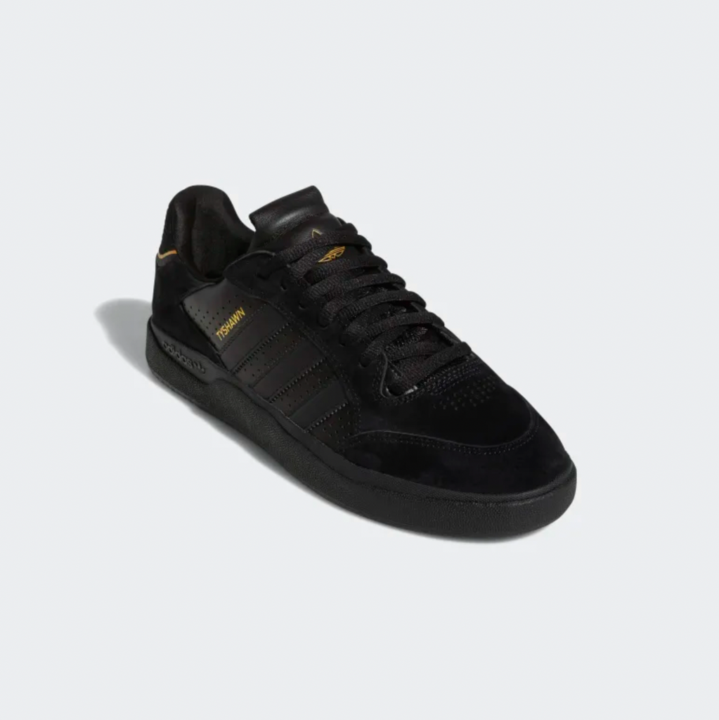 A pair of black and gold ADIDAS TYSHAWN LOW BLACK / BLACK / GOLD sneakers.