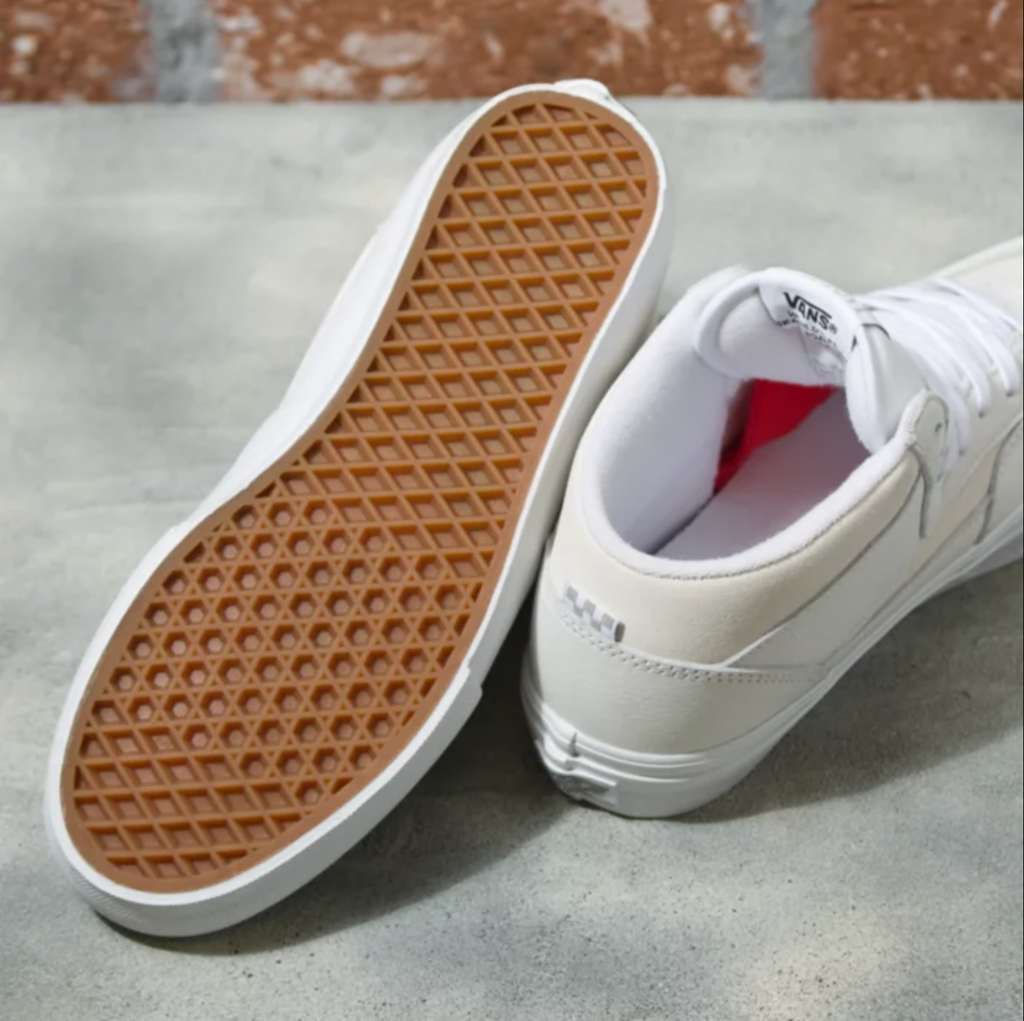 A pair of VANS DAZ SKATE HALF CAB WHITE shoes with a red sole.