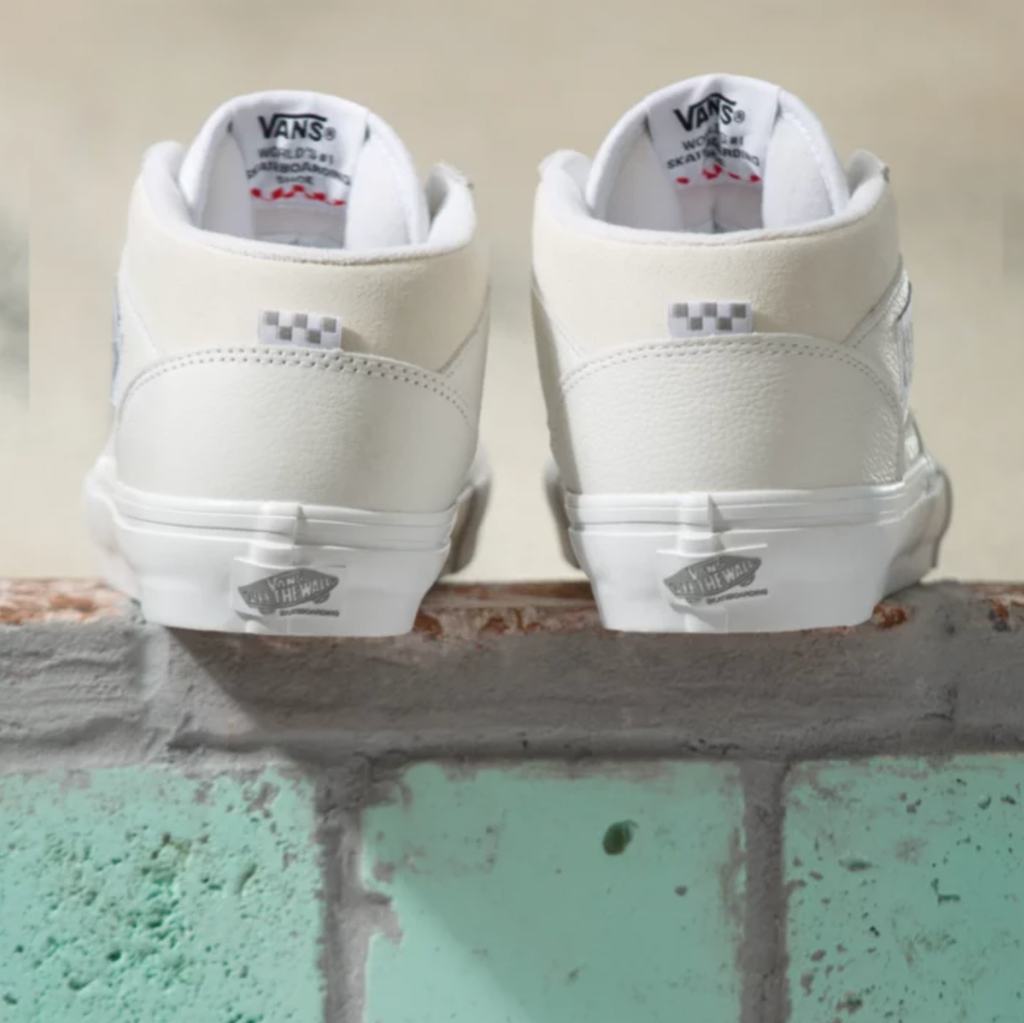 A pair of VANS DAZ SKATE HALF CAB WHITE shoes sitting on top of a brick wall.