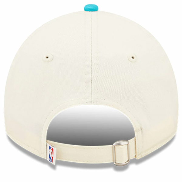 Back view of the New Era Charlotte Hornets NBA Draft OSFM baseball cap in beige, featuring an adjustable strap and a small NBA logo at the bottom, perfect for any Charlotte Hornets fan.