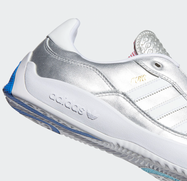 A pair of ADIDAS PUIG SILVER METALLIC / WHITE / SCARLET shoes with blue and silver accents.