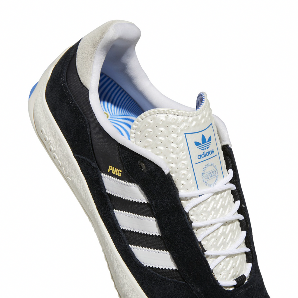 A pair of ADIDAS PUIG CORE BLACK / FLAT WHITE / BLUE BIRD sneakers.