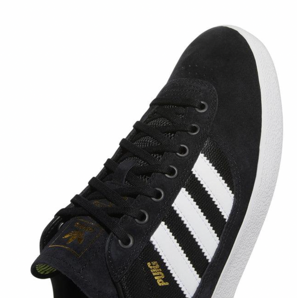A black and white ADIDAS PUIG INDOOR sneakers.