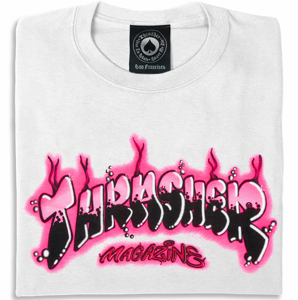 The THRASHER AIR BRUSH TEE WHITE by THRASHER features a black and pink spray-paint style "Thrasher Magazine" logo prominently displayed on the front, showcasing a vibrant, graffiti-inspired design that's perfect for streetwear enthusiasts.