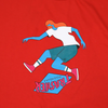 A person riding a skateboard on a red surface while wearing the THRASHER PARRA TRE FLIP TEE RED by THRASHER.