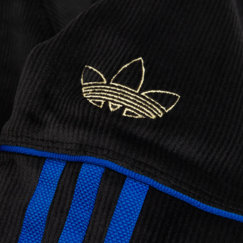 A close up of a black and blue ADIDAS TYSHAWN VELOUR JACKET.