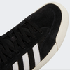 A black and white ADIDAS sneaker with white stripes.