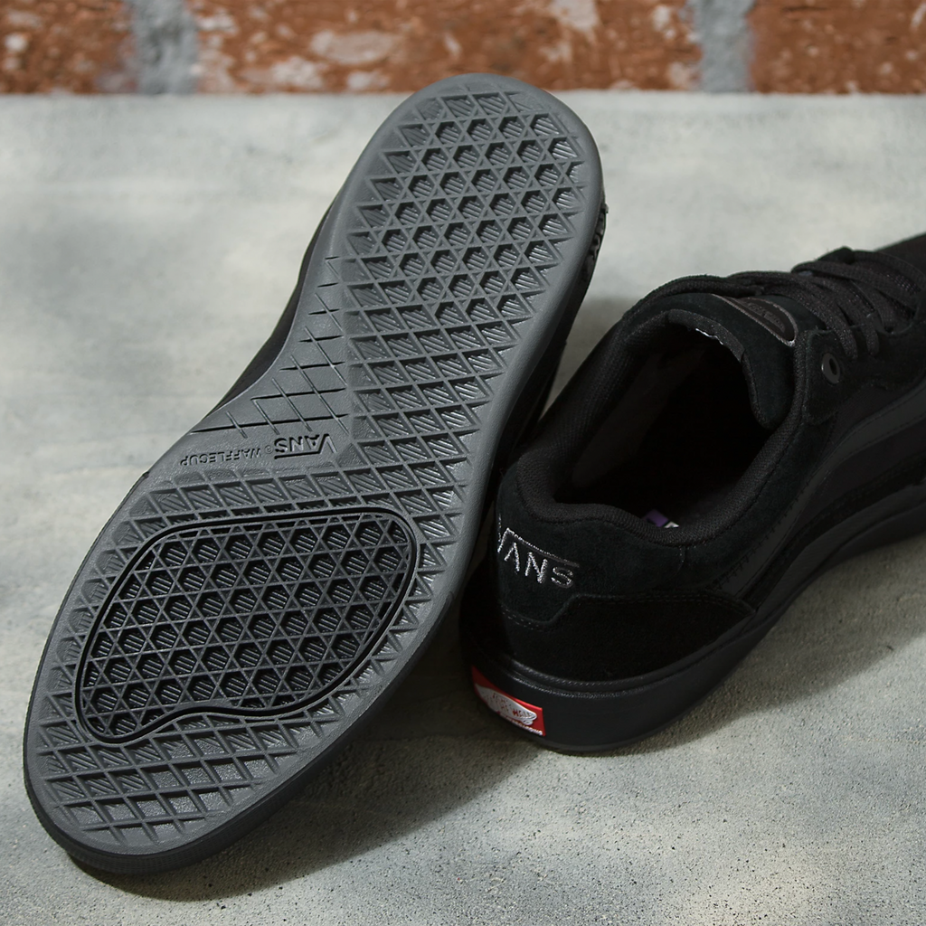 A pair of VANS SKATE WAYVEE BLACK / BLACK shoes sitting on top of a cement floor.