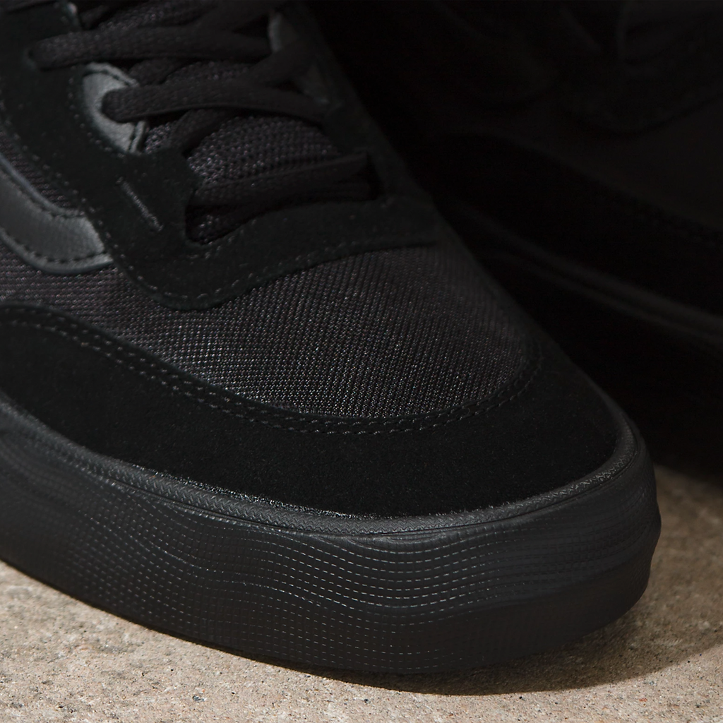 A close up of a person's VANS SKATE WAYVEE BLACK / BLACK sneakers.