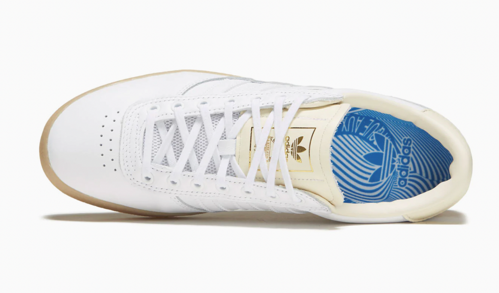 A pair of white and blue ADIDAS PUIG INDOOR WHITE / CREAM WHITE sneakers.