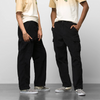 Two men standing next to each other in front of a white wall wearing VANS Corduroy Loose Tapered Cargo Pant Black.
