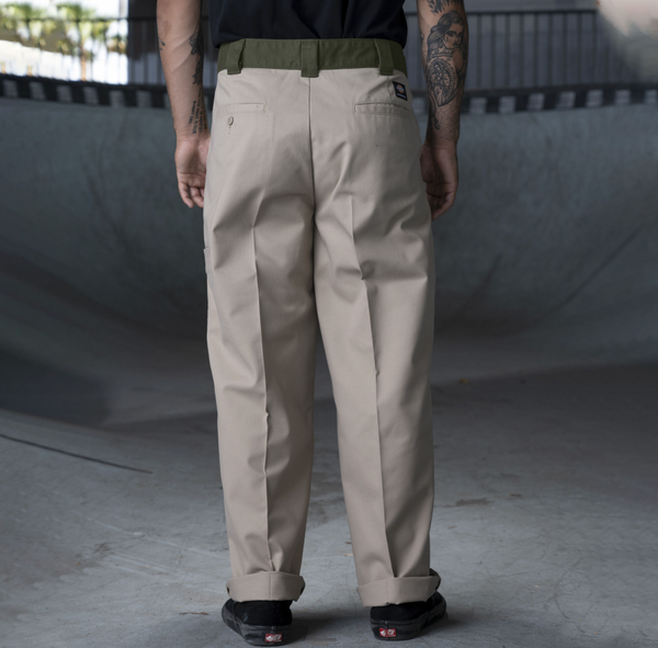 A man in a black shirt and khaki DICKIES RONNIE SANDOVAL DOUBLE KNEE PANT DESERT SAND / OLIVE.
