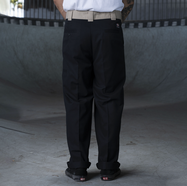 A man in a white shirt and DICKIES RONNIE SANDOVAL DOUBLE KNEE PANT BLACK/DESRT SAND.