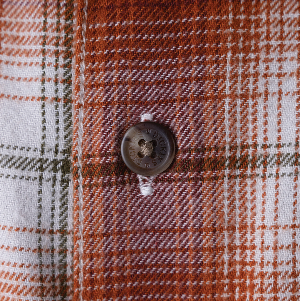 A close up of a button on a DICKIES RONNIE SANDOVAL BRUSHED FLANNEL SHIRT BURNT OMBRE.