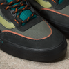 A pair of black and green VANS SKATE WAYVEE OUTDOOR UNEXPLORED sneakers with orange laces.