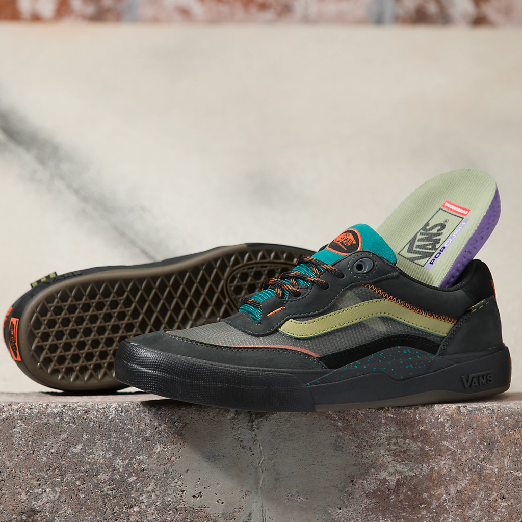 A pair of VANS SKATE WAYVEE OUTDOOR UNEXPLORED shoes sitting on top of a cement wall.