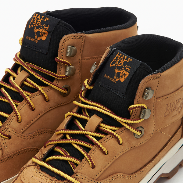 A pair of tan boots with VANS SKATE X TIMBERLAND HALF CAB HIKER WHEAT.