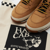 A pair of VANS SKATE X TIMBERLAND HALF CAB HIKER WHEAT sneakers with a bag on top of them.