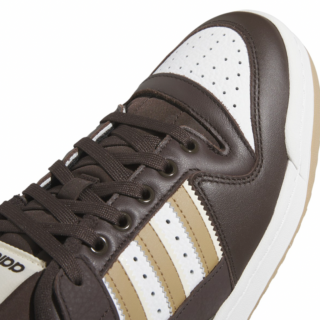 A brown and white ADIDAS FORUM 84 LOW ADV DARK BROWN / ECRU TINT / WHITE sneakers on a white background.
