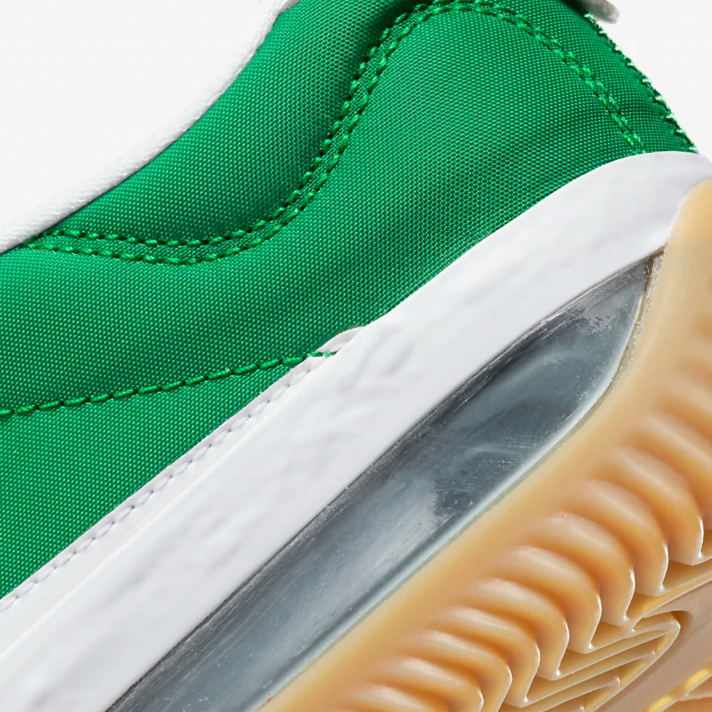 A close up of a green NIKE SB BRSB DEEP ORANGE / PINE GREEN / WHITE sneaker with white soles.